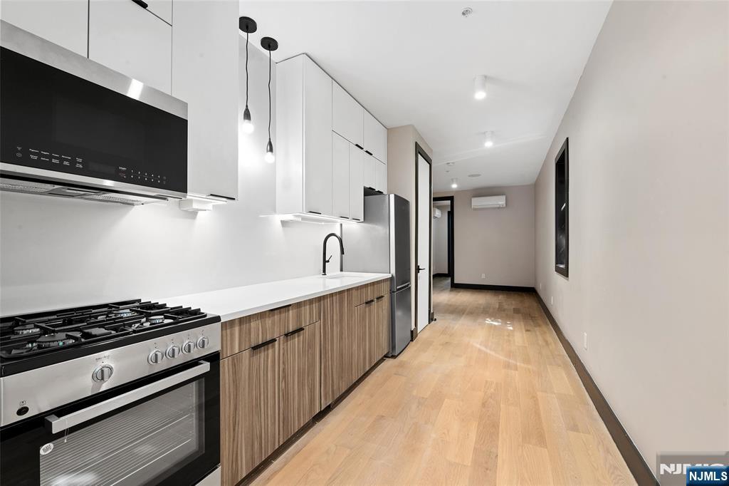 208 15th Street Jersey City, NJ 07310 - Photo 26 of 46 a kitchen with stainless steel appliances kitchen island granite countertop a stove and a sink