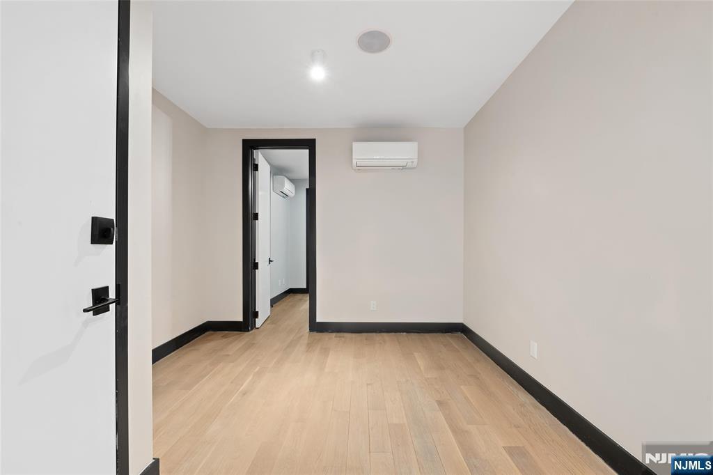 208 15th Street Jersey City, NJ 07310 - Photo 31 of 46 an empty room with wooden floor and a window