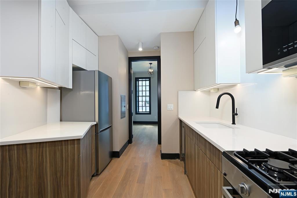 208 15th Street Jersey City, NJ 07310 - Photo 10 of 46 a kitchen with stainless steel appliances a refrigerator and a sink