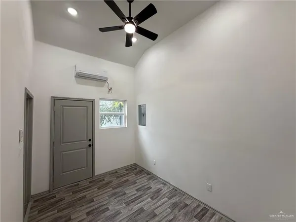 an empty room with closet and windows