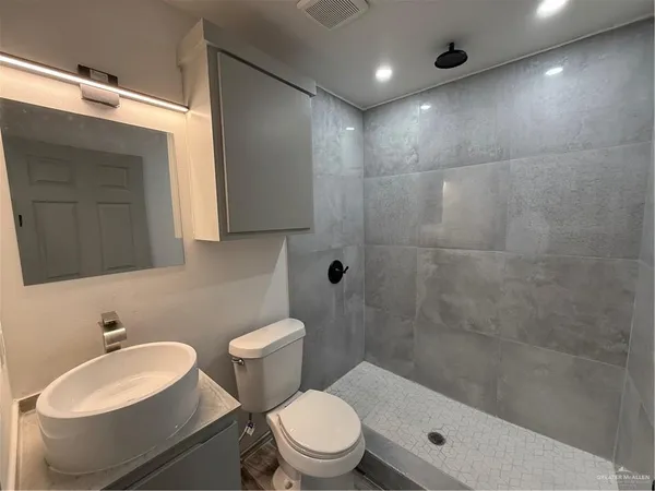 a bathroom with a sink a toilet and shower