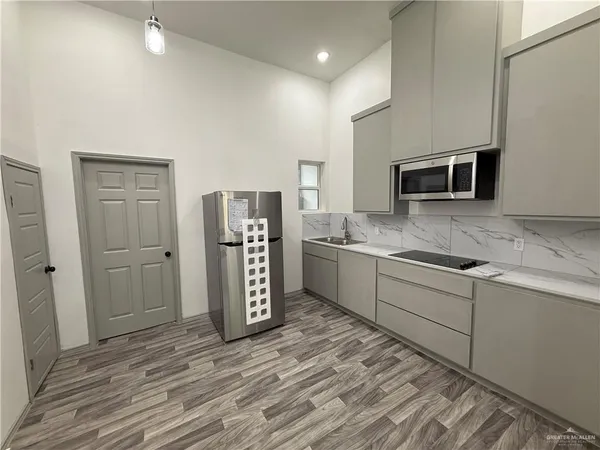 a kitchen with stainless steel appliances granite countertop a refrigerator and a stove top oven