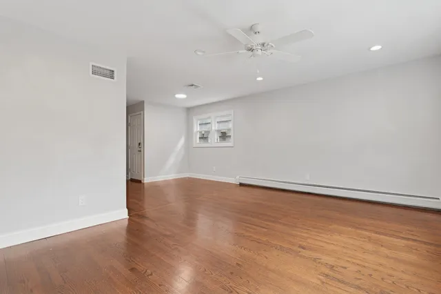 an empty room with wooden floor and window