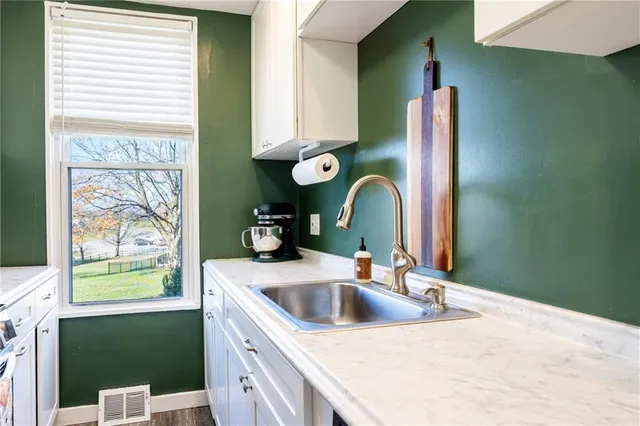 a kitchen with a sink cabinets and a window