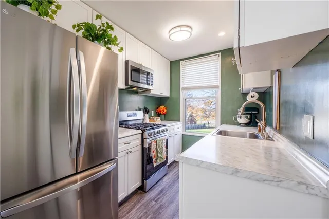 a kitchen with granite countertop a refrigerator stove and sink