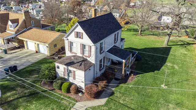 an aerial view of a house with garden space and street view