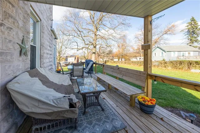 a balcony with wooden floor table and chairs
