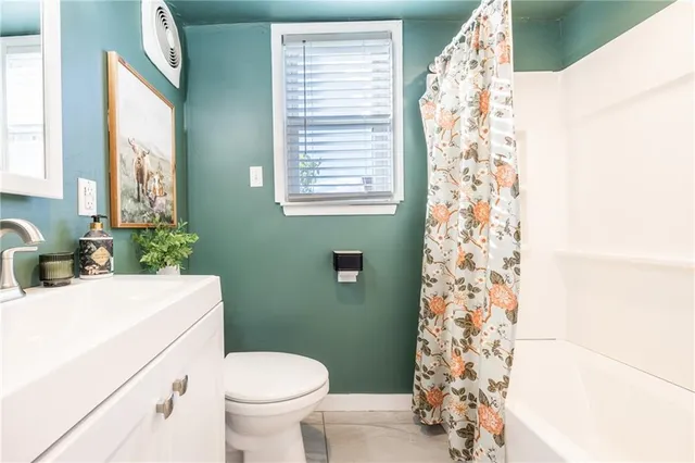 a bathroom with a sink toilet and window