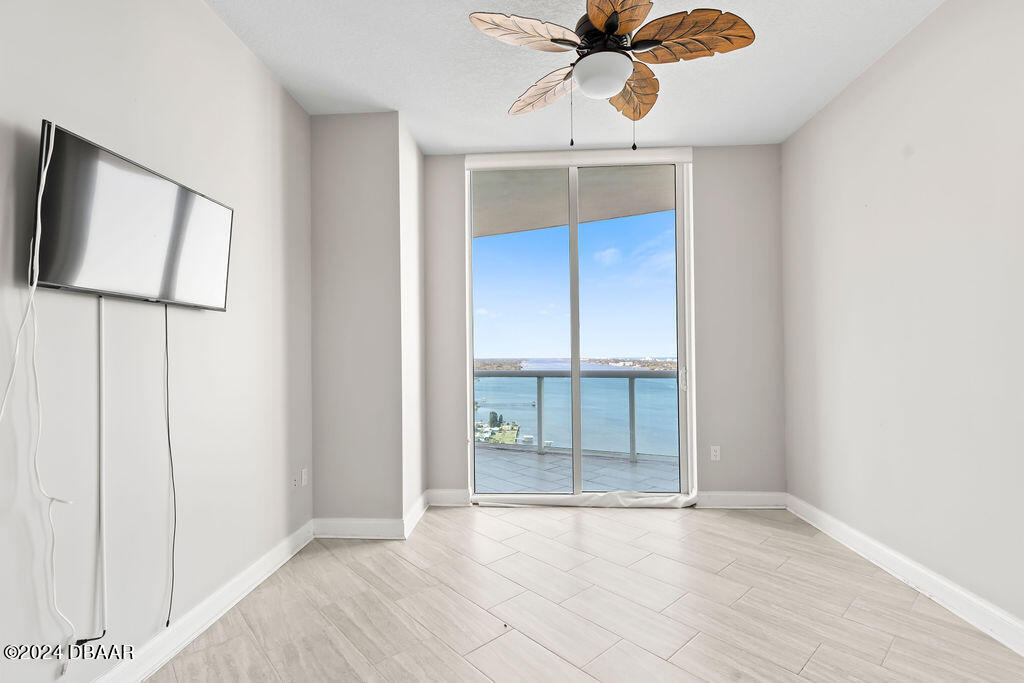 241 Riverside Drive, Unit 2610 Daytona Beach, FL 32117 - Photo 21 of 31 an empty room with chandelier fan and kitchen view