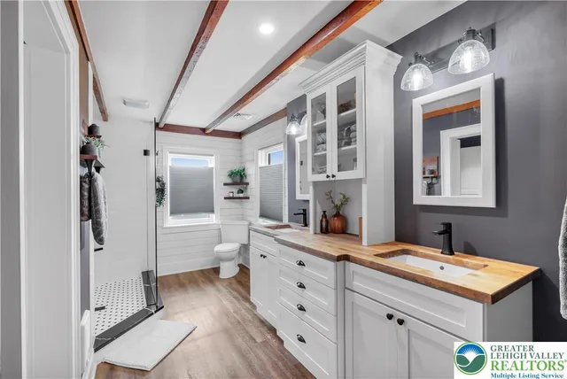 a view of a patio with table and chairs potted plants and floor to ceiling window with wooden floor