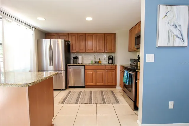 a kitchen with stainless steel appliances granite countertop a refrigerator and a sink