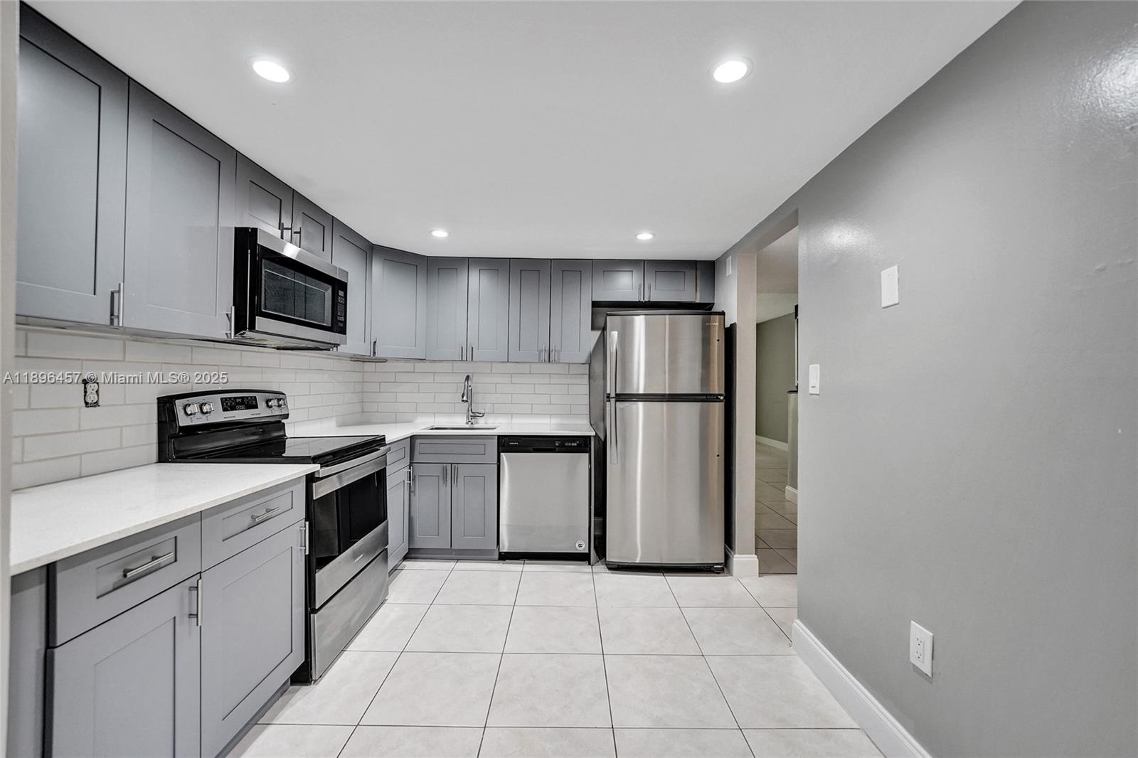 8401 West Sample Road, Unit 20 Coral Springs, FL 33065 - Photo 11 of 61 a kitchen with a sink a refrigerator and a stove top oven with wooden floor