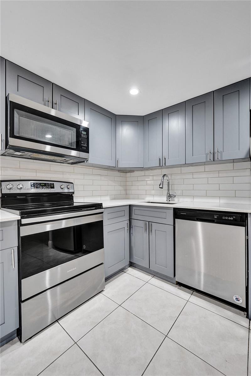 8401 West Sample Road, Unit 20 Coral Springs, FL 33065 - Photo 12 of 61 a kitchen with stainless steel appliances granite countertop a stove microwave and sink