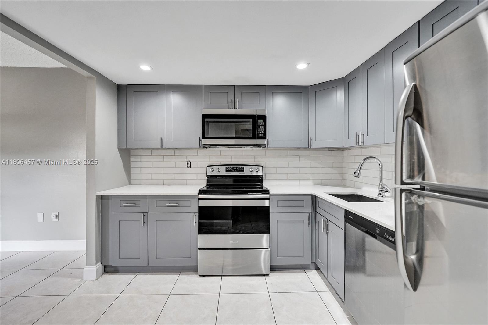 8401 West Sample Road, Unit 20 Coral Springs, FL 33065 - Photo 13 of 61 a kitchen with cabinets stainless steel appliances and a sink