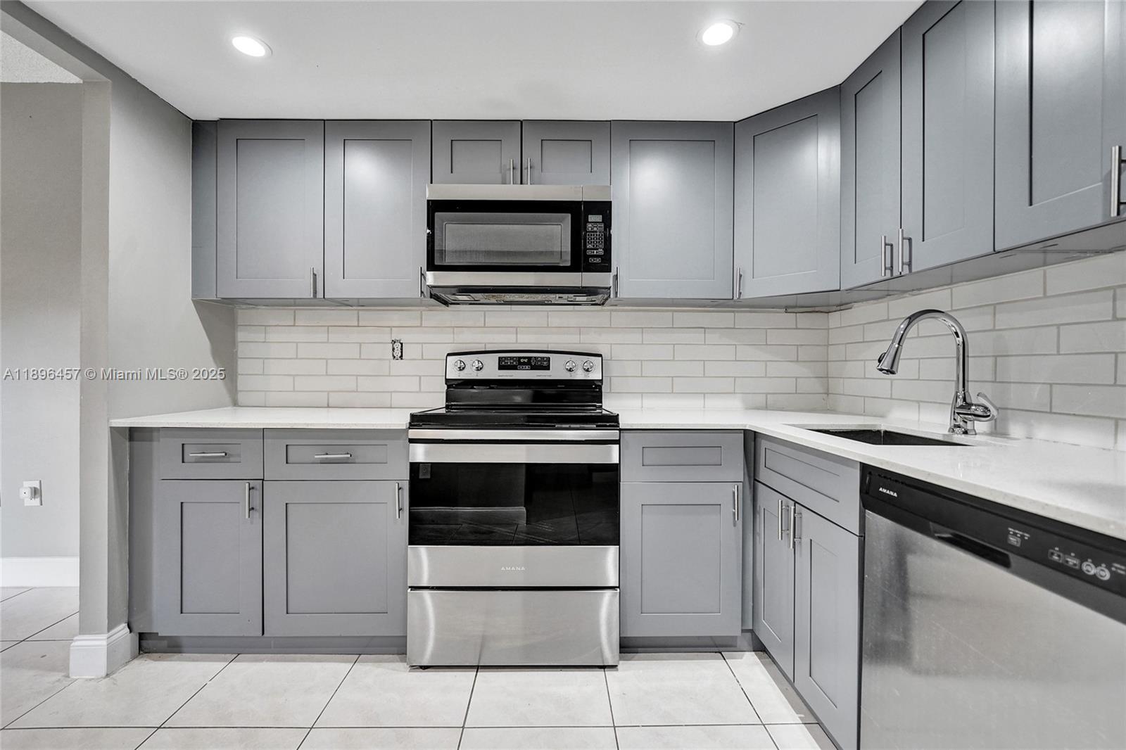 8401 West Sample Road, Unit 20 Coral Springs, FL 33065 - Photo 14 of 61 a kitchen with cabinets stainless steel appliances and a sink