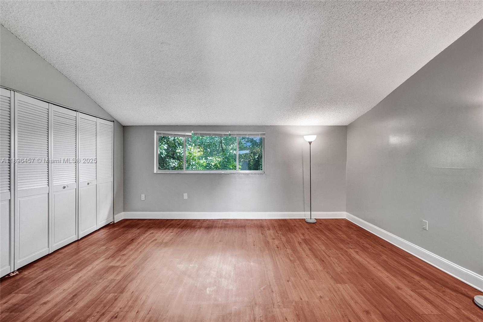 8401 West Sample Road, Unit 20 Coral Springs, FL 33065 - Photo 40 of 61 an empty room with wooden floor and windows