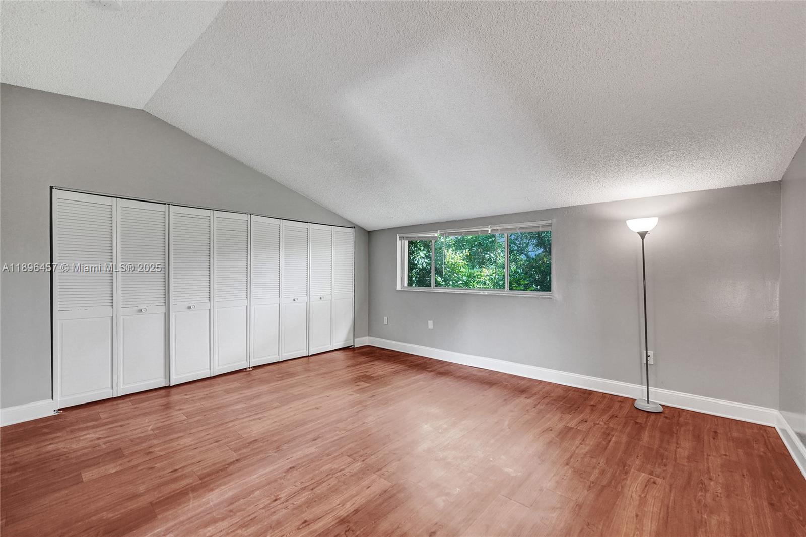 8401 West Sample Road, Unit 20 Coral Springs, FL 33065 - Photo 41 of 61 a view of an empty room with wooden floor and window