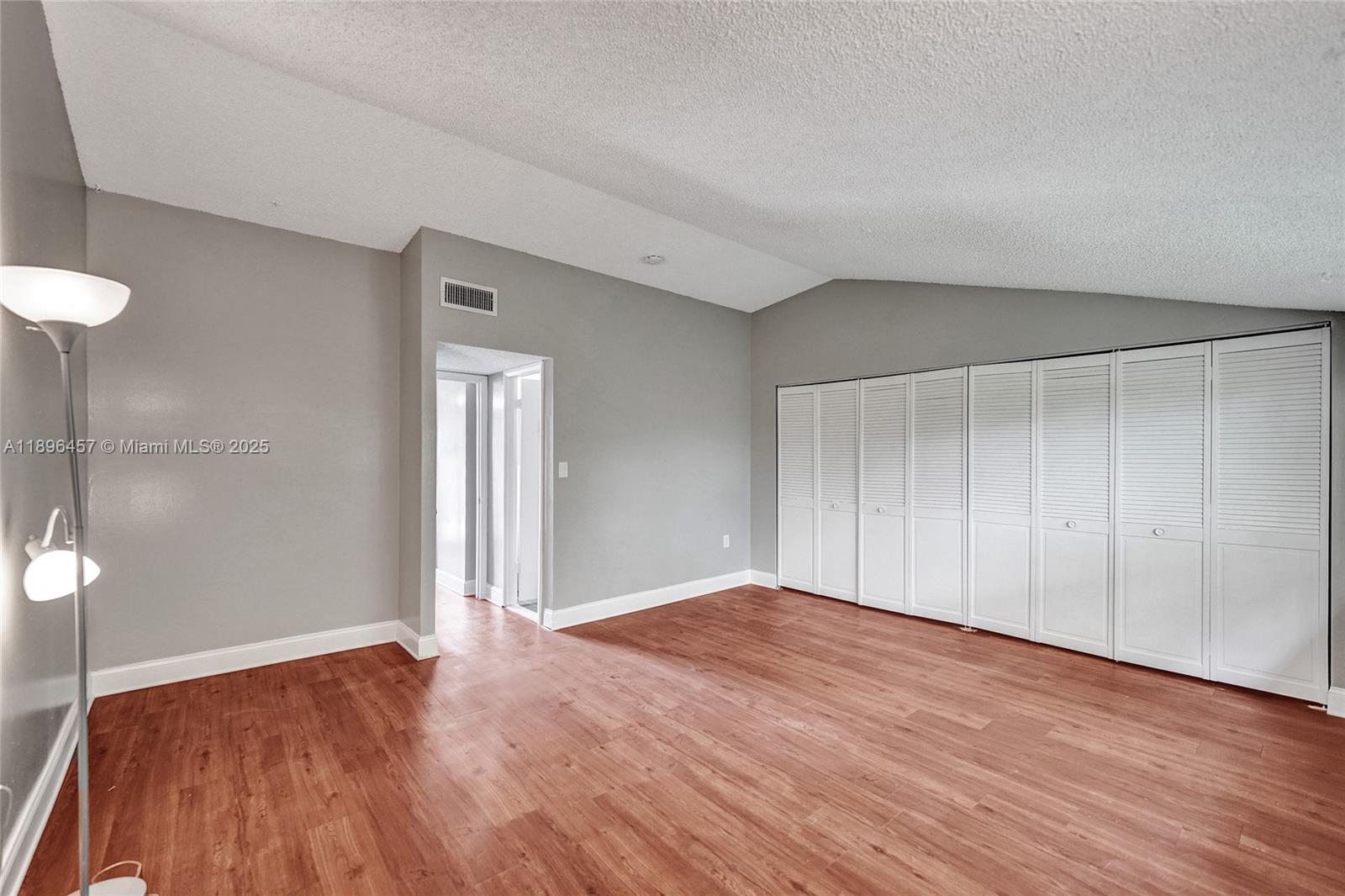 8401 West Sample Road, Unit 20 Coral Springs, FL 33065 - Photo 42 of 61 a view of an empty room with wooden floor and a bathroom