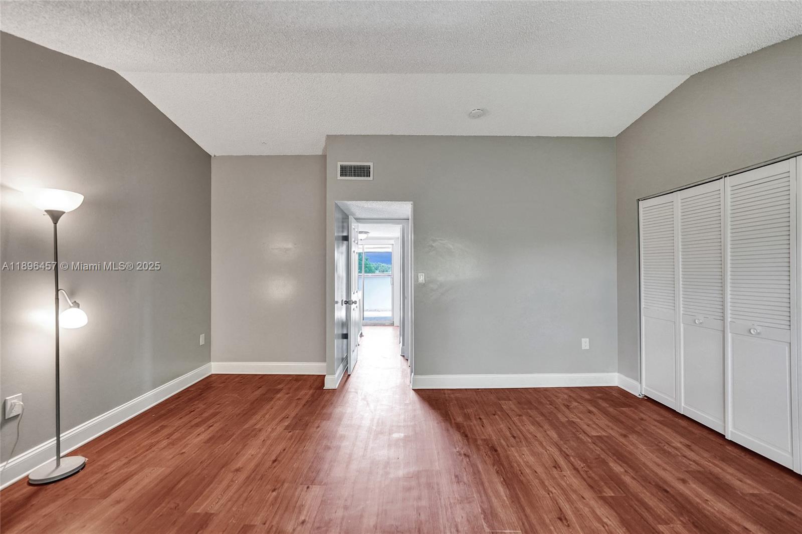 8401 West Sample Road, Unit 20 Coral Springs, FL 33065 - Photo 43 of 61 an empty room with wooden floor mirror and windows