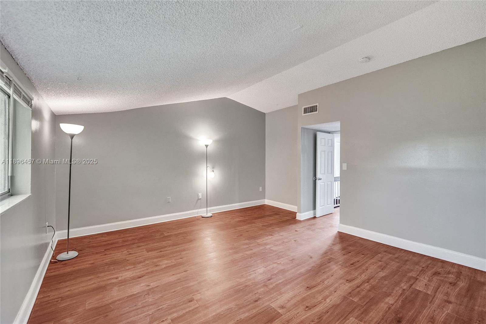 8401 West Sample Road, Unit 20 Coral Springs, FL 33065 - Photo 44 of 61 a view of an empty room with wooden floor and a window