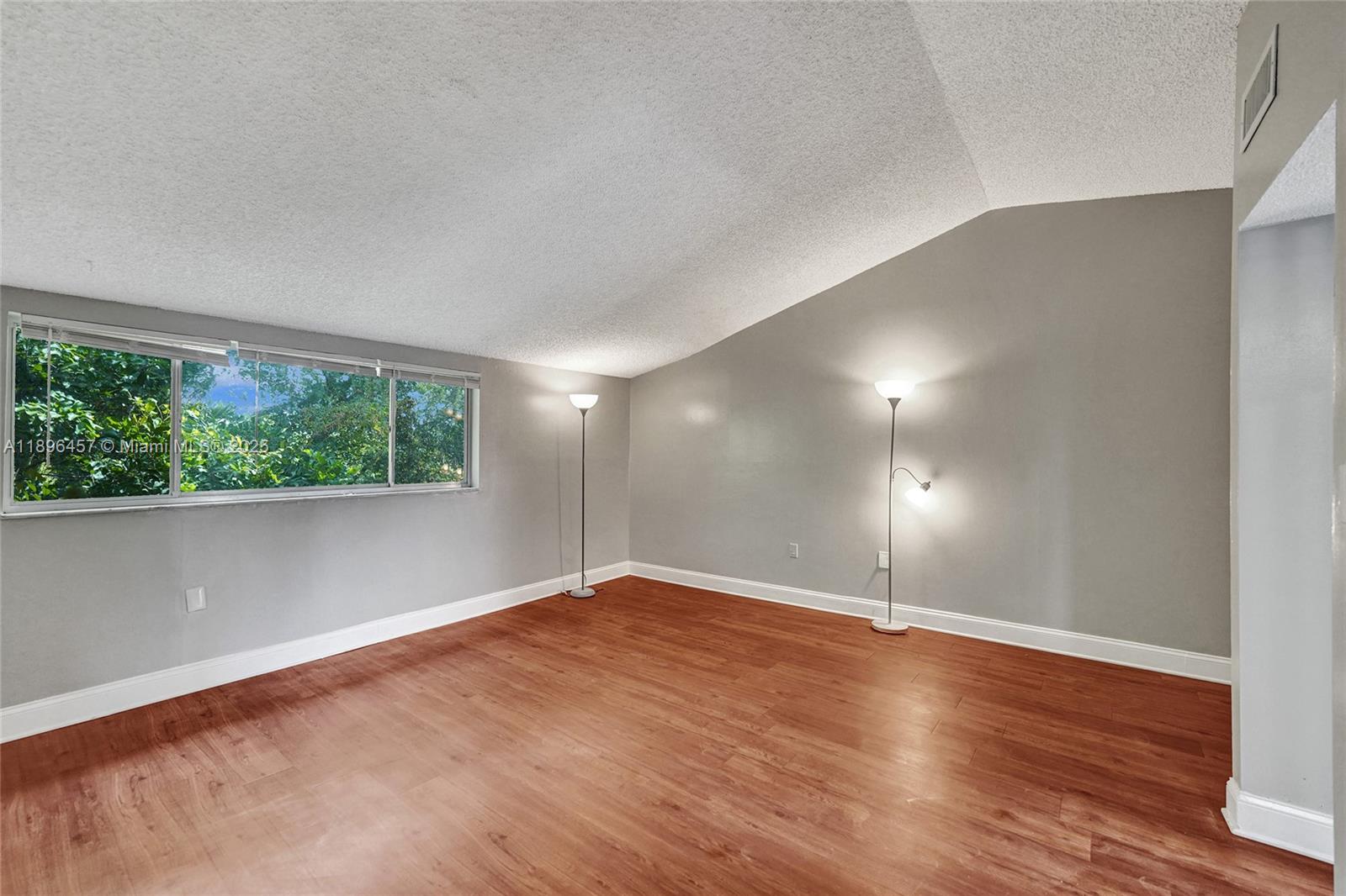 8401 West Sample Road, Unit 20 Coral Springs, FL 33065 - Photo 45 of 61 an empty room with wooden floor and windows
