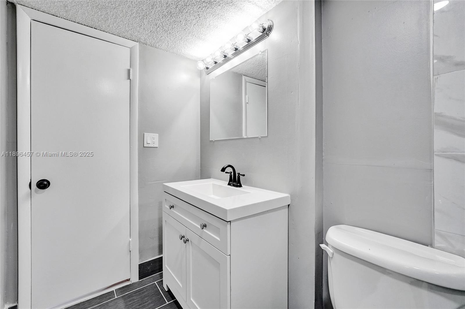 8401 West Sample Road, Unit 20 Coral Springs, FL 33065 - Photo 51 of 61 a bathroom with a sink a toilet and a mirror