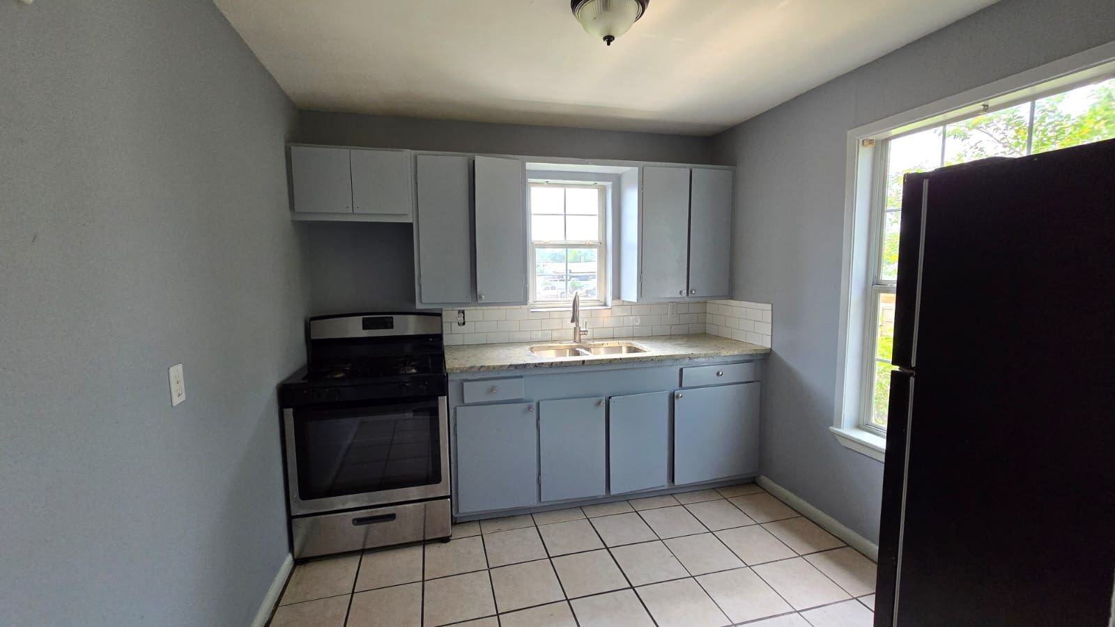 a kitchen with granite countertop a refrigerator and a sink