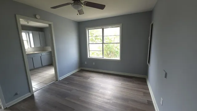 an empty room with wooden floor and windows