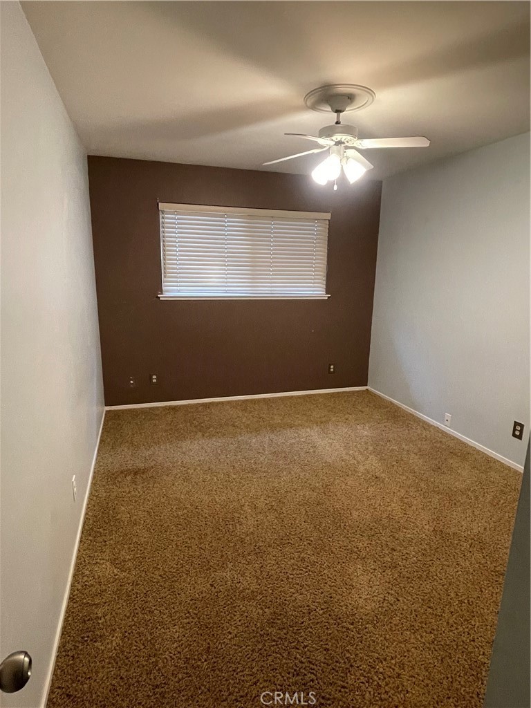 658 David Court Merced, CA 95340 - Photo 15 of 18 an empty room with a chandelier fan and windows
