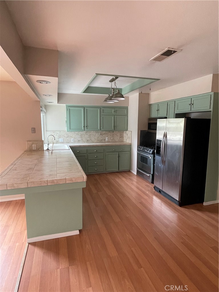 658 David Court Merced, CA 95340 - Photo 5 of 18 a kitchen with stainless steel appliances granite countertop a wooden floor and chairs