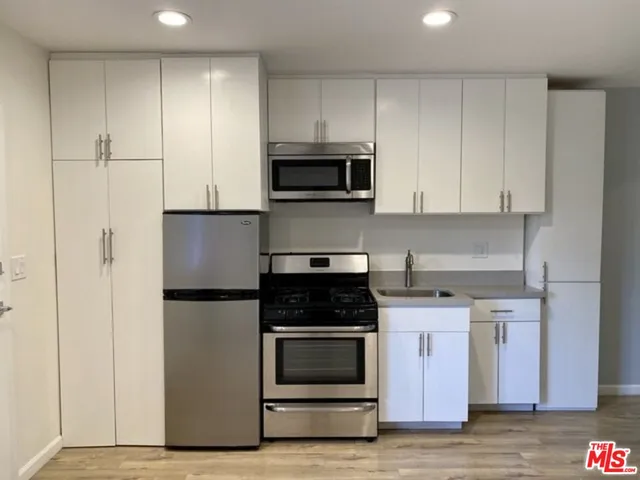 a kitchen with white cabinets and stainless steel appliances