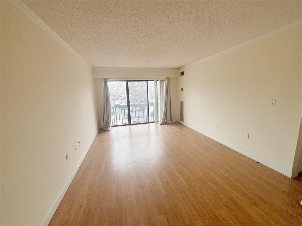15 North Beacon Street, Unit 217 Boston, MA 02134 - Photo 1 of 21 wooden floor in an empty room with a window