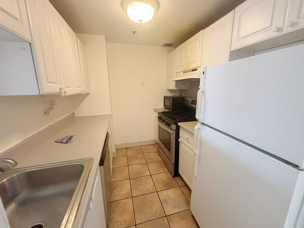 15 North Beacon Street, Unit 217 Boston, MA 02134 - Photo 3 of 21 a kitchen with a sink appliances and cabinets