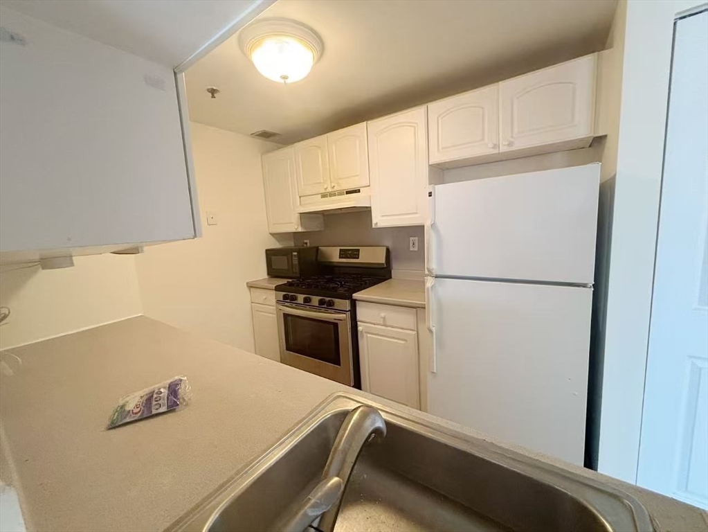 15 North Beacon Street, Unit 217 Boston, MA 02134 - Photo 4 of 21 a kitchen with a refrigerator and a stove
