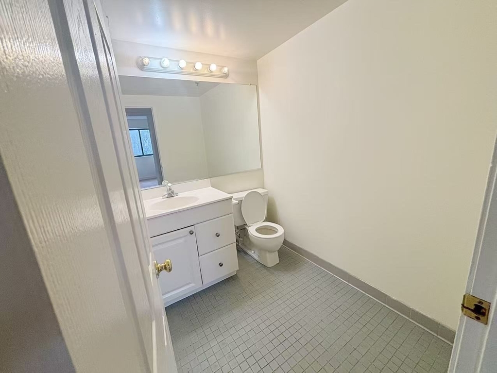 15 North Beacon Street, Unit 217 Boston, MA 02134 - Photo 7 of 21 a bathroom with a toilet sink and a mirror