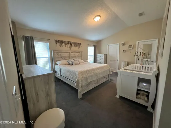 a bedroom with a bed and a mirror on dresser