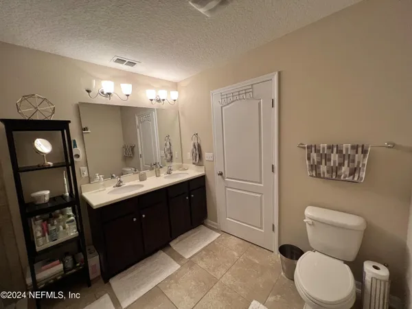 a spacious bathroom with a toilet sink and mirror