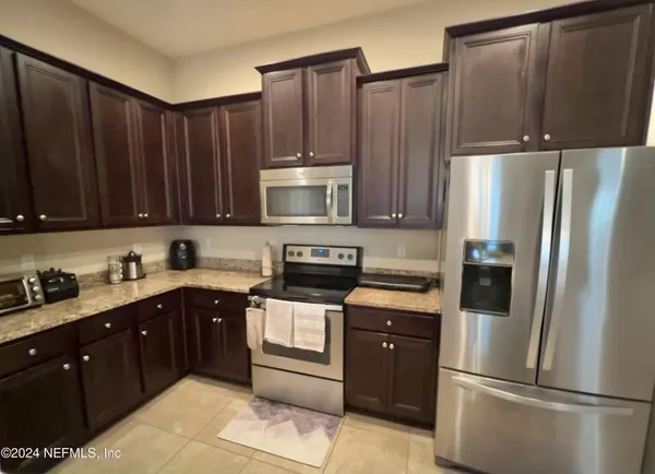 a kitchen with kitchen island wooden cabinets stainless steel appliances and a sink