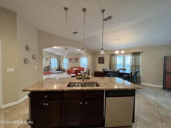 a view of a kitchen island a sink and dishwasher with wooden floor