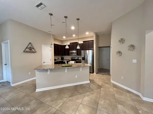 a view of a kitchen with kitchen island a counter top space stainless steel appliances and a chandelier