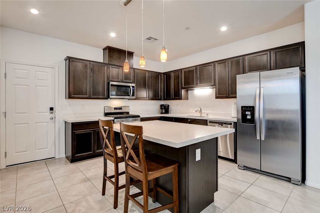 484 Filaree Place Henderson, NV 89015 - Photo 19 of 71 This contemporary kitchen features an inviting island, ample cabinet space, and sleek appliances.