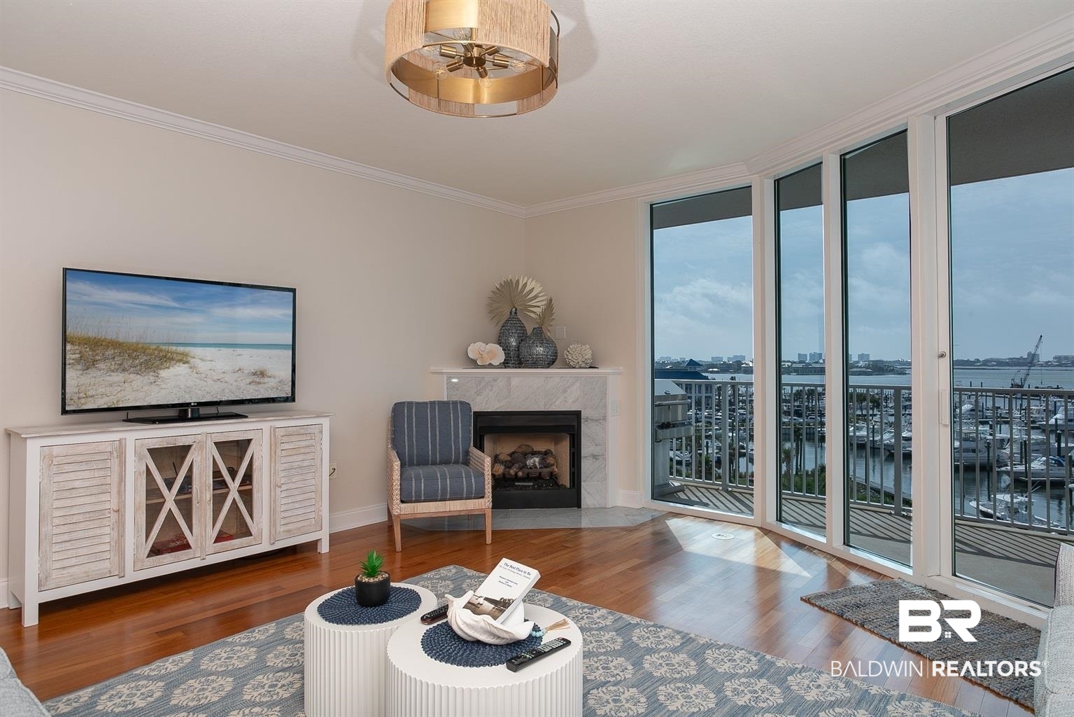 27800 Canal Road, Unit 411 Orange Beach, AL 36561 - Photo 2 of 49 Living area featuring wood-finish flooring, a corner fireplace with a marble-finish surround, and a decorative ceiling light fixture