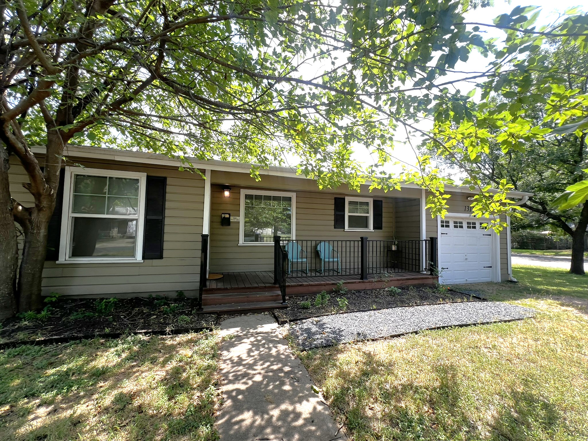 1311 Aggie Lane, Unit A Austin, TX 78757 - Photo 2 of 13 Ranch-style house featuring covered porch, an attached garage, and a front yard