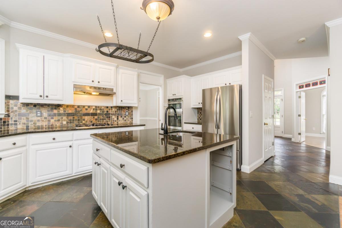 6710 Timber Cove Pointe Cumming, GA 30041 - Photo 7 of 51 a kitchen with stainless steel appliances granite countertop a sink a stove a refrigerator and island with wooden floor