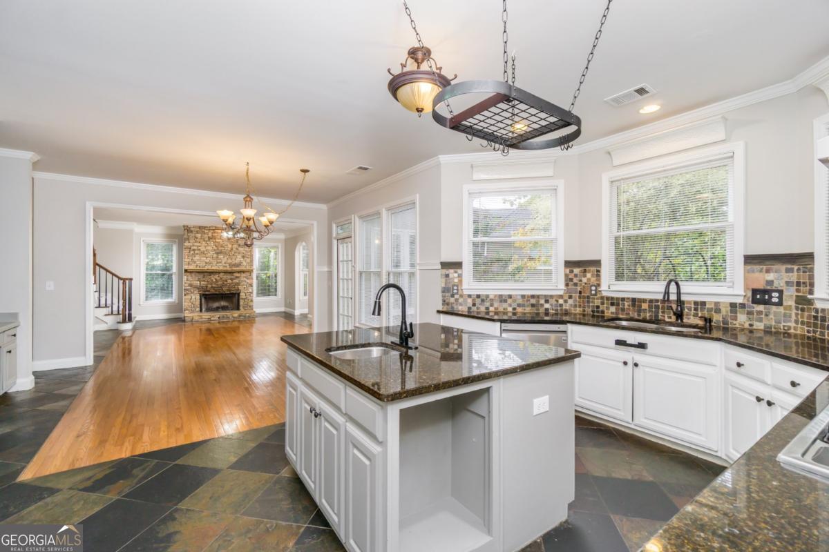 6710 Timber Cove Pointe Cumming, GA 30041 - Photo 9 of 51 a kitchen with granite countertop a sink stove and cabinets