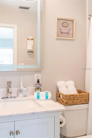 a bathroom with a granite countertop sink a toilet and a window