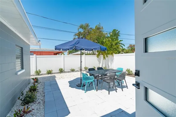 a view of a patio with table and chairs potted plants with wooden floor