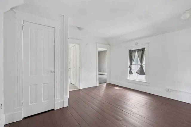 an empty room with windows and closet
