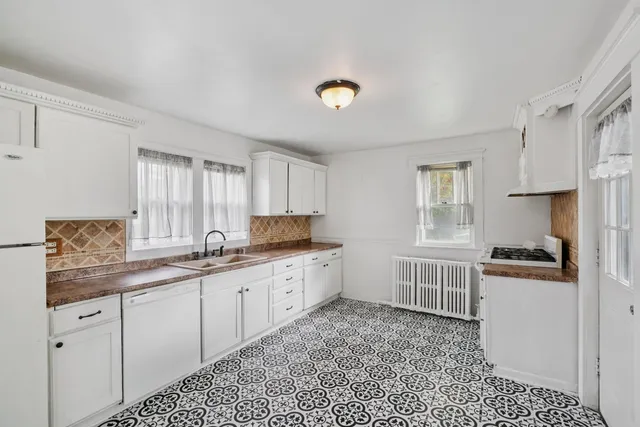 a kitchen with granite countertop white cabinets and white appliances