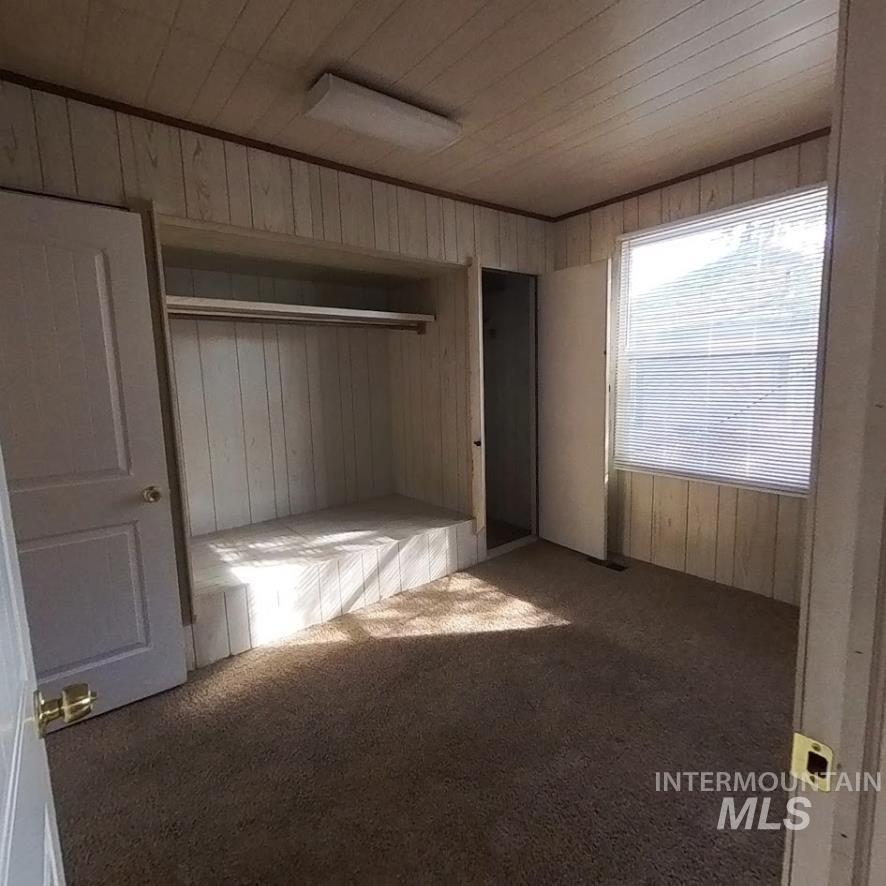 418 13th Street Clarkston, WA 99403 - Photo 11 of 26 Unfurnished bedroom with carpet floors and wooden walls
